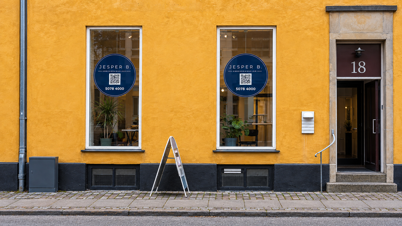 Mustardgul facade med køreskolevinduer